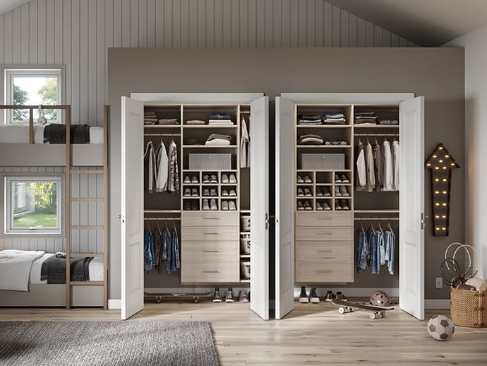 Custom kids side by side closets with built in dressers, cubbies and hanging rods by California Closets
